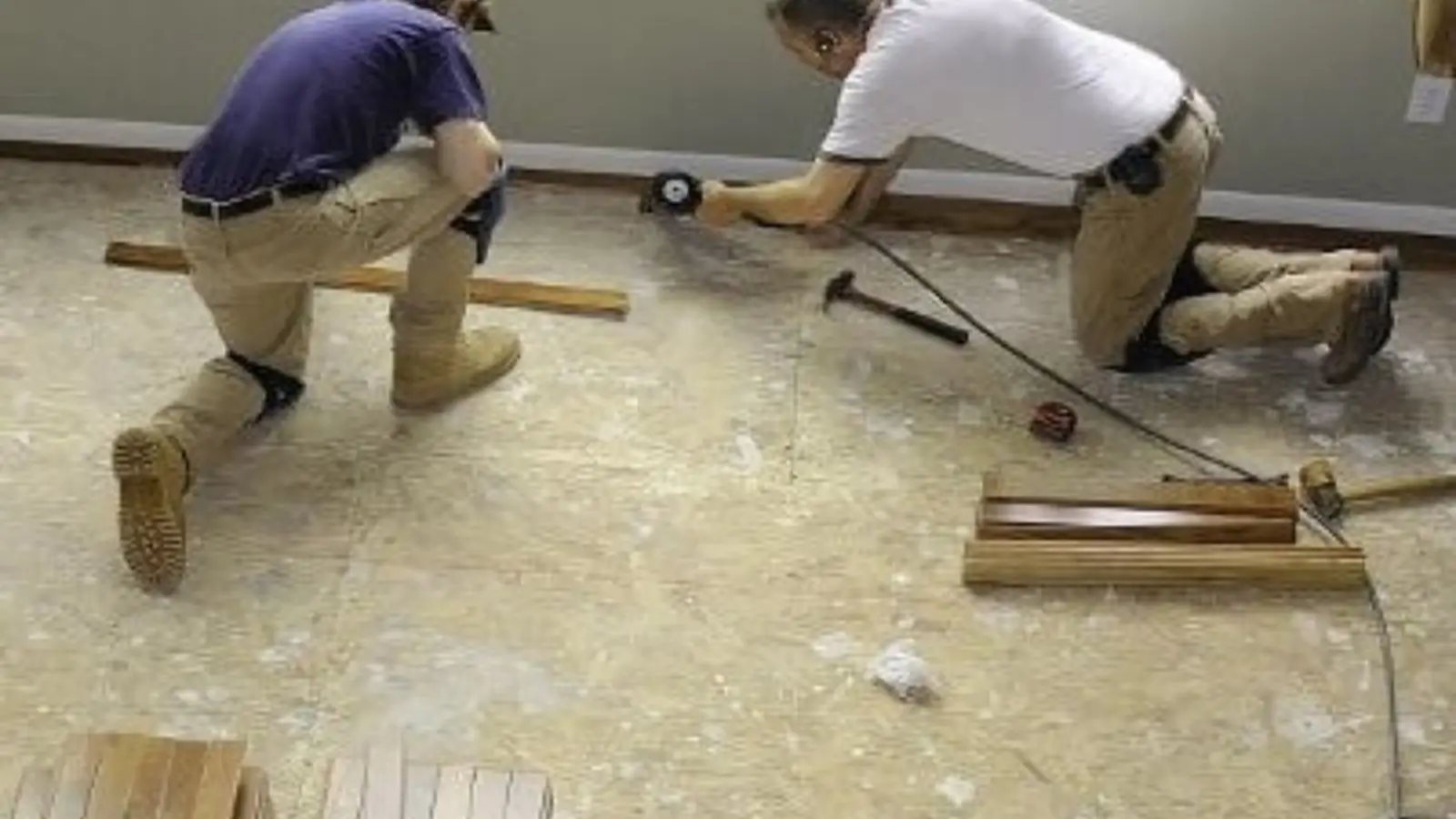 Two installers laying new flooring after water damage