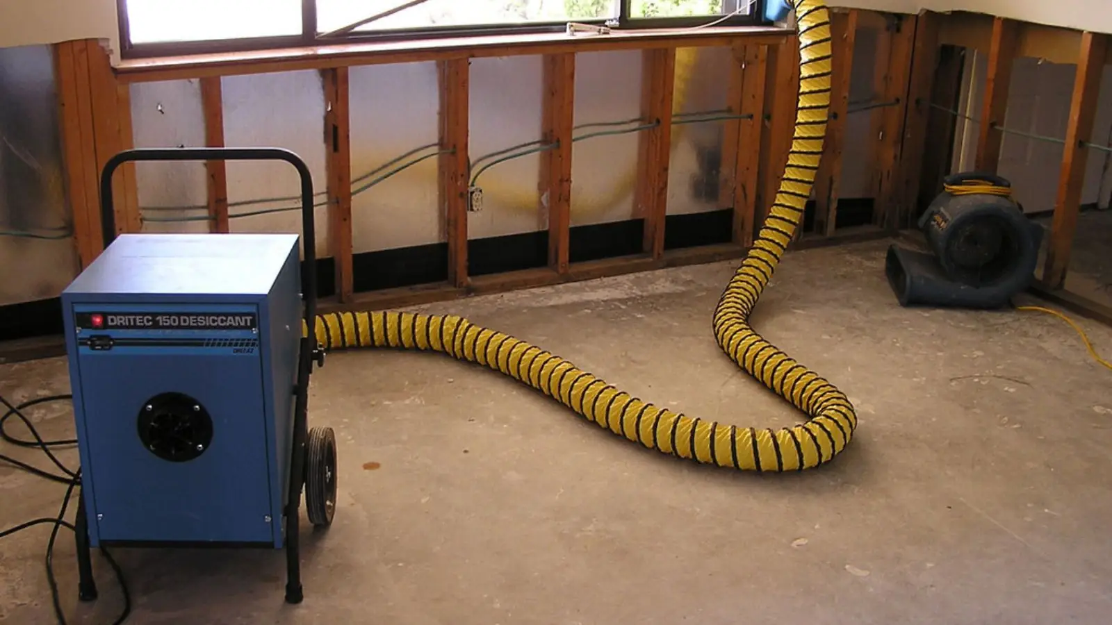 Dehumidifier and ducting drying a room with the lower wall opened up
